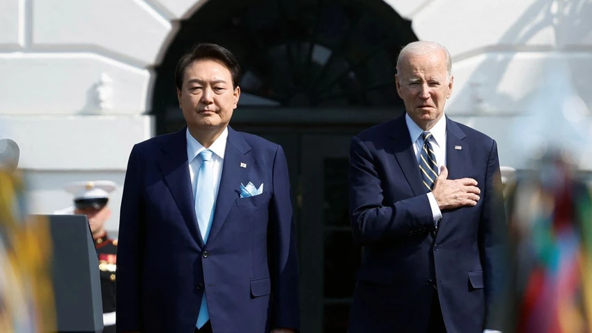Tổng thống Hàn Quốc Yoon Suk-yeol (trái) và Tổng thống Mỹ Joe Biden. Ảnh: CNN President Joe Biden and South Korea's President Yoon Suk Yeol listen to their countries' national anthems together during an official White House State Arrival Ceremony on the South Lawn of the White House in Washington, DC, on April 26.