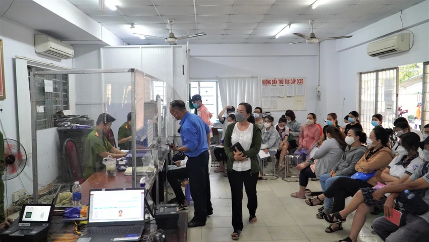 Người dân, phụ huynh và học sinh ngồi trật tự đợi làm CCCD. Ảnh: MINH TÂM