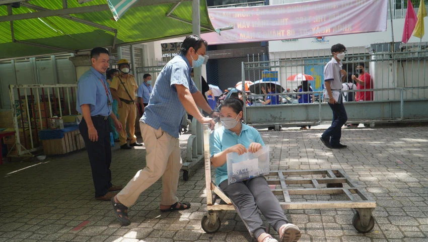 Cán bộ coi thi dùng xe đẩy em đến cầu thang và hỗ trợ dìu Nhi lên tận phòng thi. Cán bộ coi thi dùng xe đẩy em đến cầu thang và hỗ trợ dìu Nhi lên tận phòng thi.