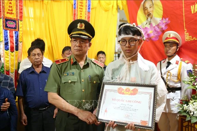 Thiếu tướng Lê Vinh Quy, Giám đốc Công an tỉnh Đắk Lắk trao Bằng Tổ quốc ghi công cho gia đình Thiếu tá Hoàng Trung, cán bộ Công an xã Ea Ktur, huyện Cư Kuin. Ảnh: TTXVN