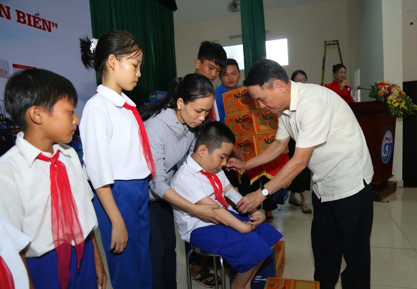 Em Nguyễn Văn Minh Trí, học sinh lớp 6C Trường Tiểu học - THCS Gio Việt, huyện Gio Linh được các bạn đoàn viên thanh niên bế lên sân khấu do em không thể di chuyển. Từ khi lọt lòng mẹ, Trí đã bị dị tật tứ chi, không thể tự lo sinh hoạt cá nhân. Bằng nỗ lực chăm lo của mẹ và ý chí mạnh mẽ, Trí đã rèn được cách viết bằng hai chân. Ba năm liền đạt danh hiệu học sinh giỏi, Trí chia sẻ lớn lên muốn trở thành bác sĩ để chữa bệnh cho mọi người. Ảnh: HOÀNG GIANG Em Nguyễn Văn Minh Trí, học sinh lớp 6C Trường Tiểu học - THCS Gio Việt, huyện Gio Linh được các bạn đoàn viên thanh niên bế lên sân khấu do em không thể di chuyển. Từ khi lọt lòng mẹ, Trí đã bị dị tật tứ chi, không thể tự lo sinh hoạt cá nhân. Bằng nỗ lực chăm lo của mẹ và ý chí mạnh mẽ, Trí đã rèn được cách viết bằng hai chân. Ba năm liền đạt danh hiệu học sinh giỏi, Trí chia sẻ lớn lên muốn trở thành bác sĩ để chữa bệnh cho mọi người. Ảnh: HOÀNG GIANG