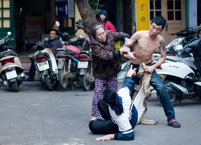 Giữa lòng đường, gần khu vực chợ Hàng Bè, mặc cho thanh niên cởi trần cầm kéo đâm một phụ nữ lớn tuổi, người dân hai bên vỉa hè chỉ dám ngồi xem. Chỉ có một cụ bà chạy tới can ngăn. Giữa lòng đường, gần khu vực chợ Hàng Bè, mặc cho thanh niên cởi trần cầm kéo đâm một phụ nữ lớn tuổi, người dân hai bên vỉa hè chỉ dám ngồi xem. Chỉ có một cụ bà chạy tới can ngăn.