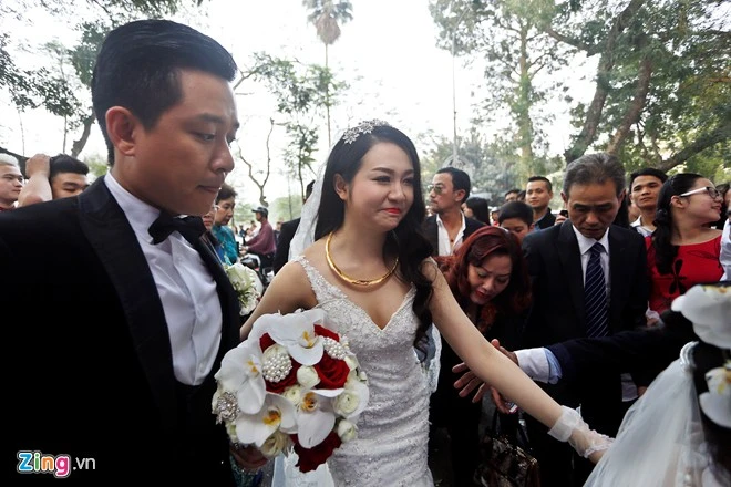 Cô dâu 9X diện chiếc váy cưới có phần cổ được cắt cúp khá táo bạo. Tuy nhiên, đuôi váy khiến Thu Hương gặp khó khăn khi di chuyển. Không chỉ các thành viên trong gia đình, Tuấn Hưng cũng luôn có mặt để hỗ trợ Hương Baby lúc tiến về xe hoa. Nhập mô tả cho ảnh