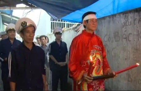Ông Bùi Văn Oanh (áo đỏ) thực hiện nghi lễ an táng. Ông Bùi Văn Oanh (áo đỏ) thực hiện nghi lễ an táng