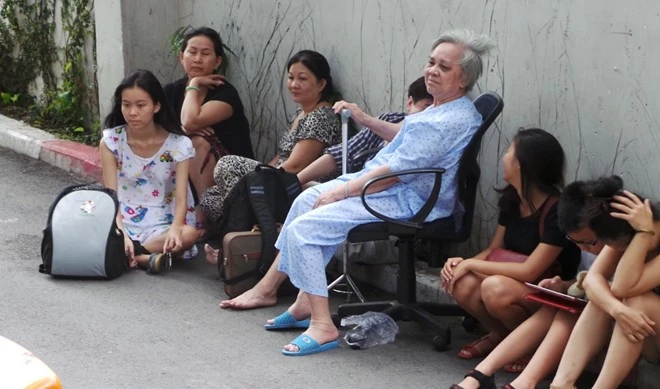 Người già và trẻ em được cõng ra ngoài. Người già và trẻ em được cõng để di tản nhanh nhất xuống đất. Nhiều người rất lo lắng và hồi hộp chờ đợi.