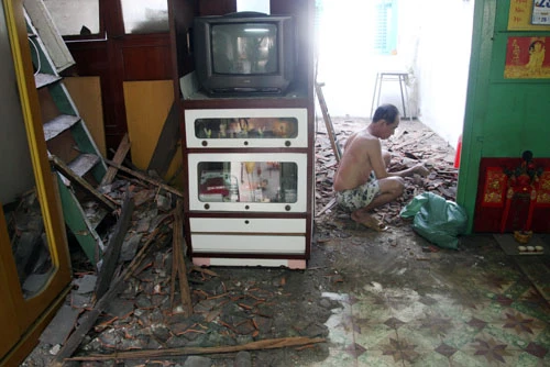 Ông Phát đang thu dọn phần ngói đổ sập xuống. Ảnh:An Nhơn Ông Phát đang thu dọn phần ngói đổ sập xuống. Ảnh: An Nhơn