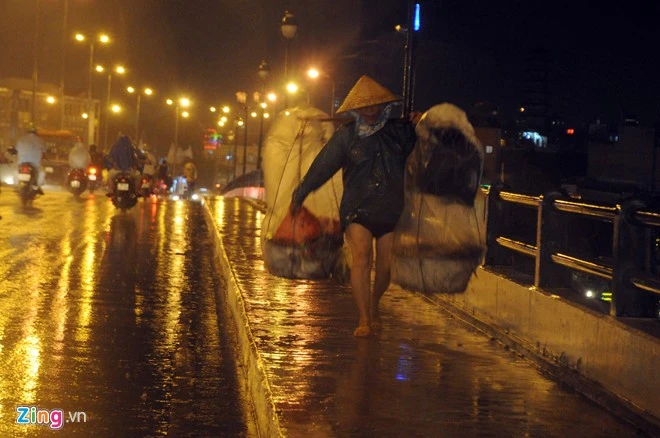 Người phụ nữ buôn thúng, bán gánh với tấm áo mưa chỉ đến thắt lưng đi như chạy trong cơn mưa bất chợt. Sài Gòn bắt đầu vào mùa mưa, người phụ nữ buôn thúng bán ghánh đi như chạy dưới cơn mưa tầm tã.