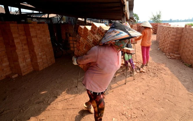 Mỗi người phụ nữ nơi đây đèo trên lưng từ 50 -60 viên gạch thẻ cho mỗi lần di chuyển - Ảnh: Thanh Tùng Mỗi người phụ nữ nơi đây đèo trên lưng từ 50 -60 viên gạch thẻ cho mỗi lần di chuyển - Ảnh: Thanh Tùng