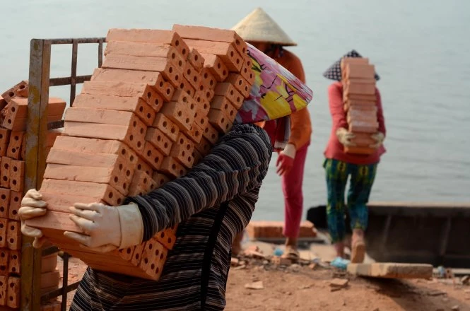 Sức nặng đè trên vai người phụ nữ - Ảnh: Thanh Tùng Sức nặng đè trên vai người phụ nữ - Ảnh: Thanh Tùng