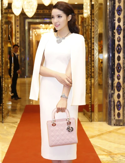 Hoa hậu Kỳ Duyên diện trang phục trắng của nhà thiết kế Linh Đoàn. Cô kết hợp trang phục với túi xách Dior. 4-8636-1426899937.jpg