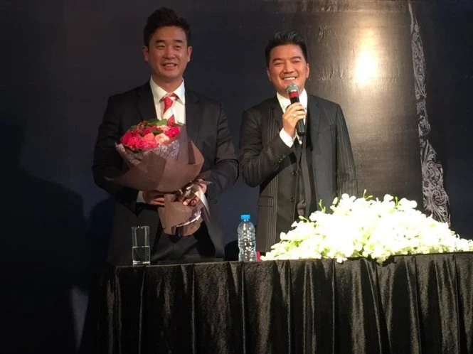 Ca sĩ Đàm Vĩnh Hưng tặng hoa cảm ơn đến đại diện ban tổ chức giải Ngôi sao châu Á, ông Lee Sun Ki tại họp báo vào chiều 16-11 - Ảnh: Q.N.