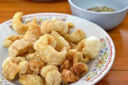 Tsitsaron là một món ăn vặt phổ biến được du nhập từ Tây Ban Nha, có tên gọi khác là chicharrón. Bì lợn được rán giòn, ăn kèm với đu đủ xanh hoặc giấm ớt. Bạn có thể tìm thấy món ăn này ở hầu khắp các nhà hàng và quầy bán rong tại Manila. Ảnh: Enwikimedia trung-vit-lon-mon-an-sang-pho-bien-o-philippines-1