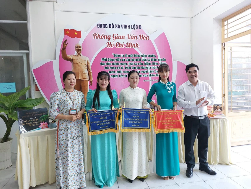 Tại buổi lễ ra mắt, ông Nguyễn Thành Nhân, Bí thư Đảng ủy xã Vĩnh Lộc B (bên phải) và bà Trần Thị Thái Nguyên, Chủ tịch UBND xã trao giải thưởng Hội thi xây dựng tập san “Không gian văn hoá Hồ Chí Minh” cho các đơn vị là các Chi bộ Trường học, các ấp trên địa bàn xã.