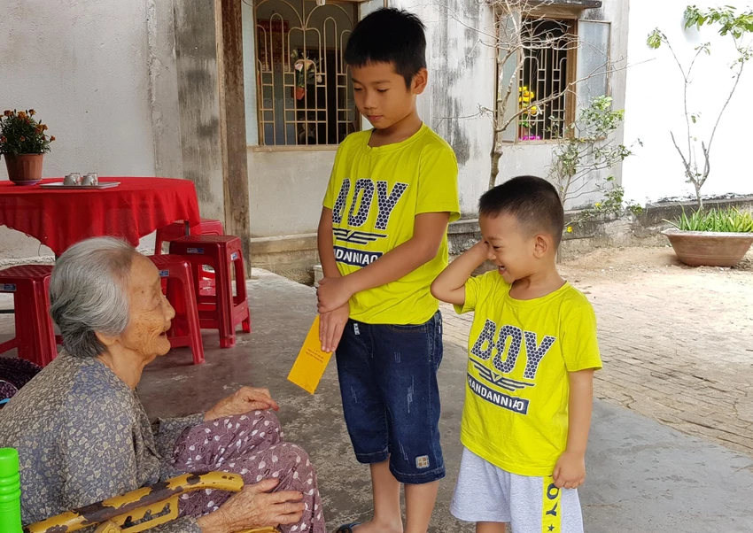 Bà mừng tuổi cháu ngày tết Nguyên đán. Ảnh: DUY TÍNH Bà mừng tuổi cháu ngày tết Nguyên đán. Ảnh: DUY TÍNH