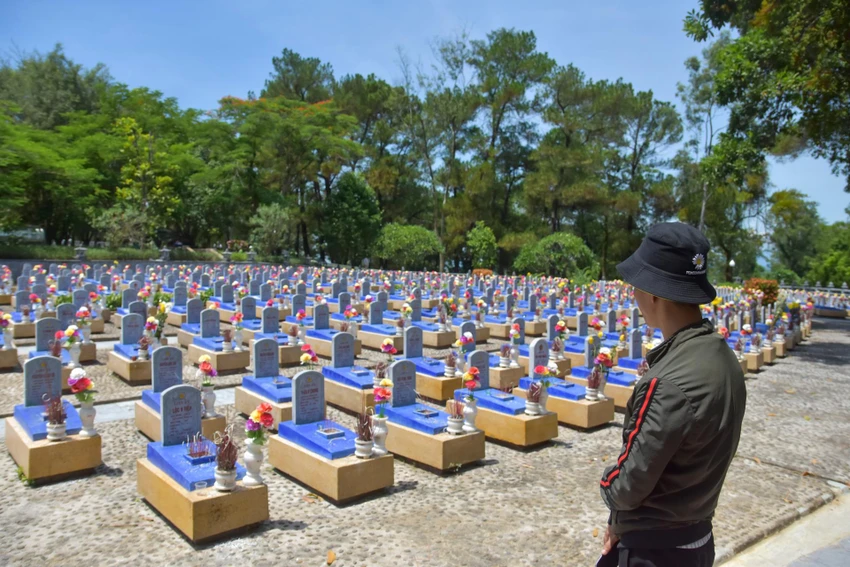 Một người dân thẩn thờ nhìn các ngôi mộ liệt sĩ trước lúc rời Nghĩa trang liệt sĩ Quốc gia Trường Sơn. Ảnh: NGUYỄN DO