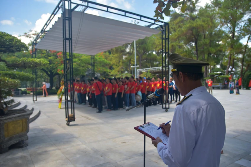 Ông Hoàng Văn Minh, Phó trưởng Ban quản lý nghĩa trang tổ chức lễ viếng cho các đoàn. Ảnh: NGUYỄN DO