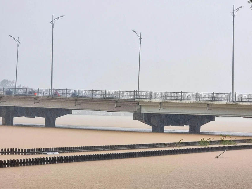 Cầu gỗ lim trên sông Hương bị ngập chỉ còn thấy đỉnh của lan can hai bên cầu. Cầu gỗ lim trên sông Hương bị ngập chỉ còn thấy đỉnh của lan can hai bên cầu.