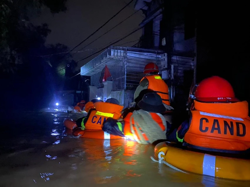 Lực lượng chức năng hỗ trợ người dân thoát khỏi nước lũ.