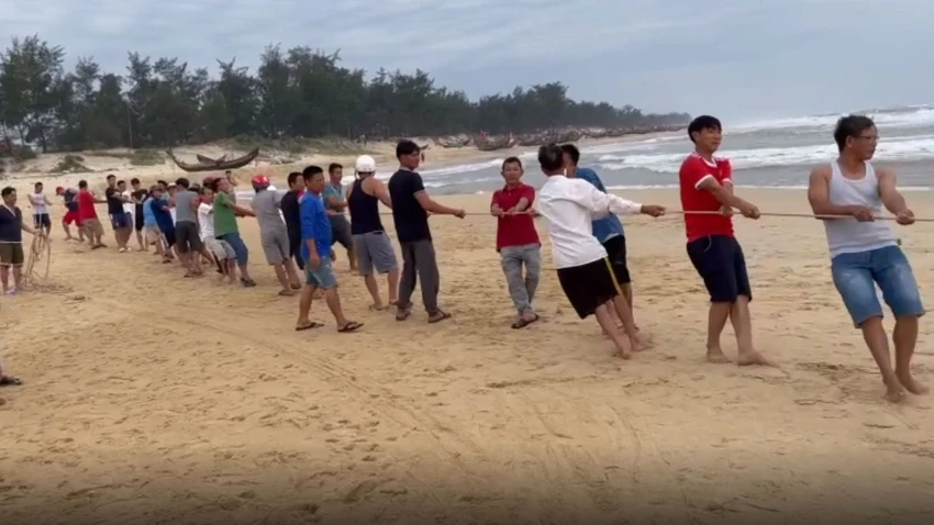 Người dân hỗ trợ đưa tàu cá gặp nạn vào bờ.