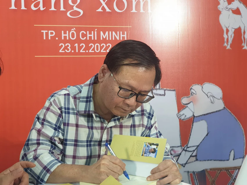 Nhà văn ký tặng sách cho bạn đọc. Ảnh: VĂN HÀ