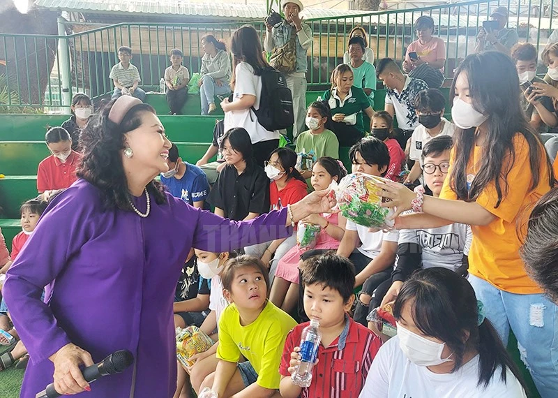 NSND Kim Cương ân cần trao quà cho các em nhỏ. Ảnh: T.H