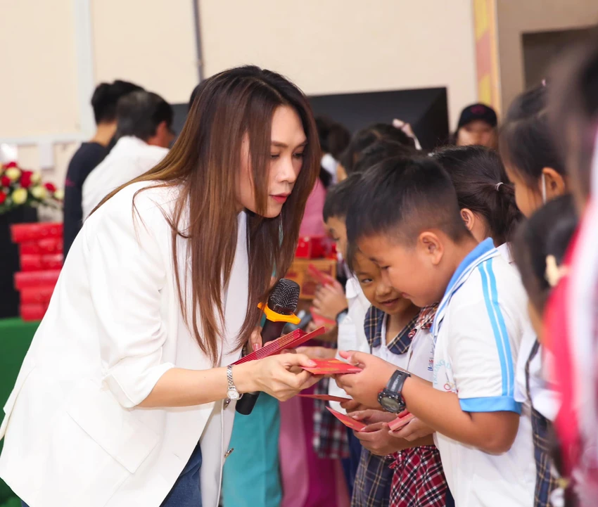 Nữ ca sĩ trao những phần quà cho các em học sinh Nữ ca sĩ trao những phần quà cho các em học sinh