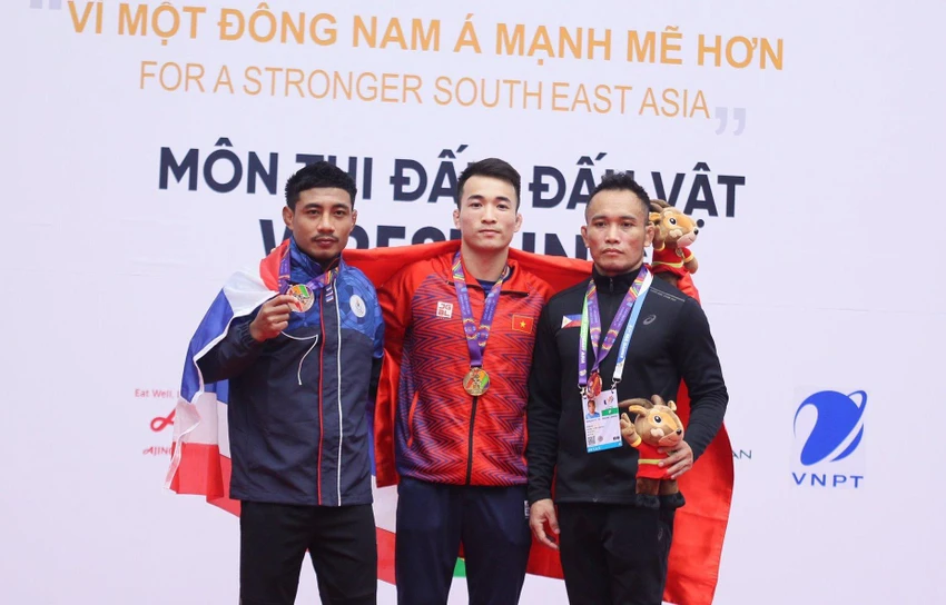 VĐV Bùi Tiến Hải (giữa) chụp ảnh lưu niệm với các đối thủ trên bục nhận huy chương. ẢNH: QUÝ LƯỢNG