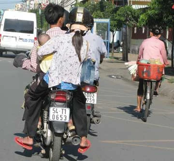 Nguyễn Duy Hòa và Nguyễn Thị Kim Hai cùng một đứa trẻ “bắt cặp” trên đường di chuyển trên đường Hùng Vương (TP.HCM) đến chỗ hành nghề.
