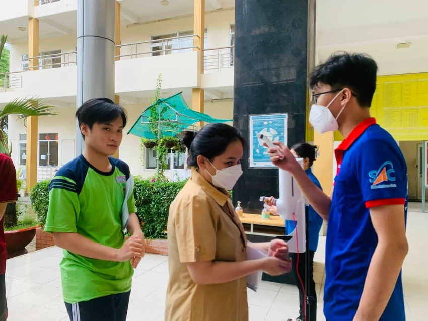 Các em được đo thân nhiệt, xịt khuẩn rửa tay trước khi vào điểm thi. Ảnh: TP Các em được đo thân nhiệt, xịt khuẩn rửa tay trước khi vào điểm thi. Ảnh: TP