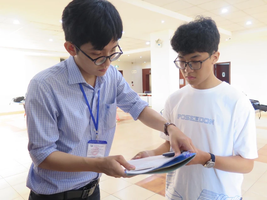 Cán bộ gọi tên và kiểm tra thông tin thí sinh trước khi vào phòng thi sáng 26-3. Ảnh: PA Cán bộ gọi tên và kiểm tra thông tin thí sinh trước khi vào phòng thi sáng 26-3. Ảnh: PA