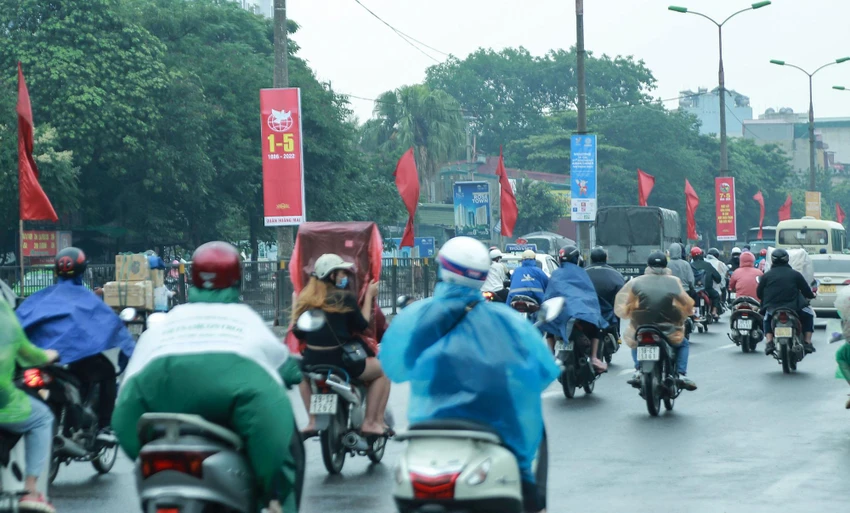 Thời tiết có lúc mưa nặng hạt, nhiều người phải mặc áo mưa, di chuyển chậm chạp.