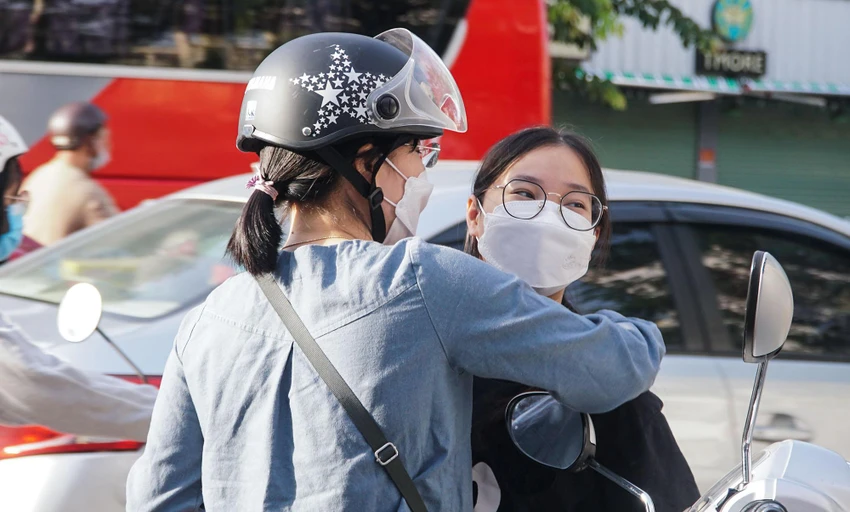Phụ huynh ôm nhẹ con vào lòng, để động viên con làm bài tốt.