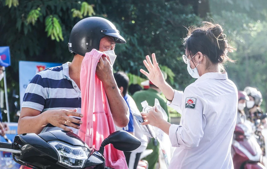 Một thí sinh giơ tay chào bố trước khi vào thi.