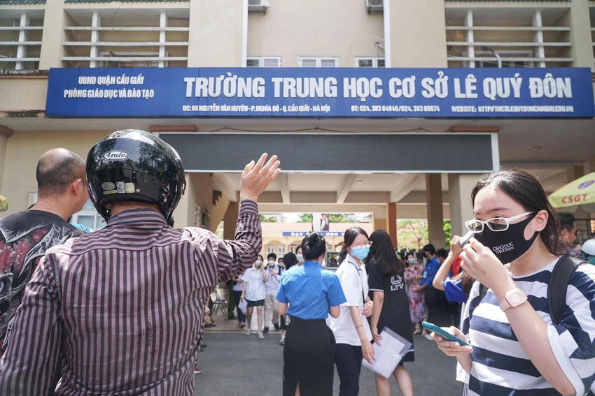Sau khi hoàn thành môn thi, những cánh tay của phụ huynh giơ cao để chào đón các con bước ra khỏi phòng thi.