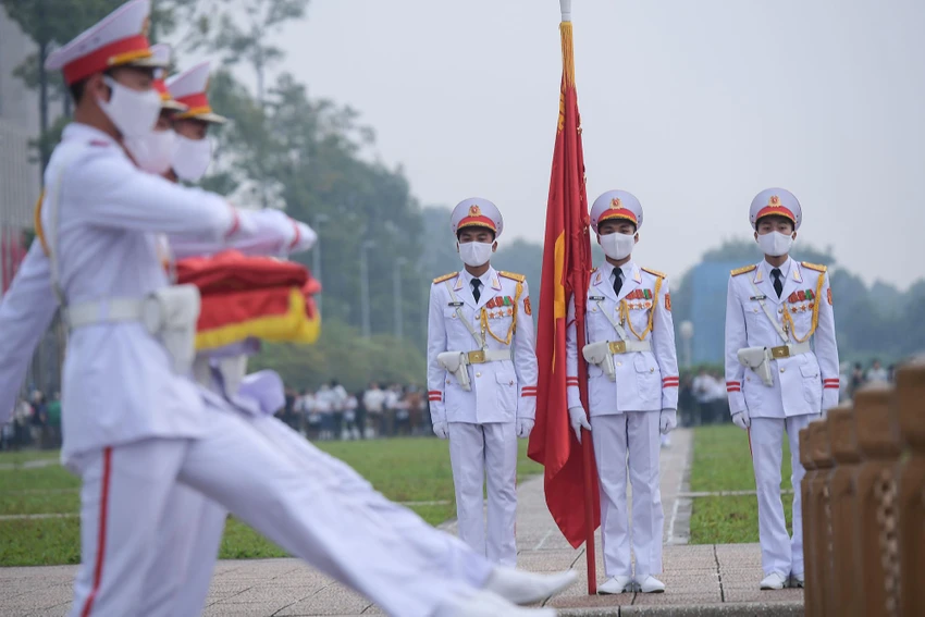 Đoàn đi một vòng ra phía trước theo tiếng nhạc của ca khúc 'Tiến bước dưới quân kỳ' để đến chân cột cờ. Ba chiến sĩ đội hồng kỳ tiến lên phía cột cờ chuẩn bị các nghi thức Thượng cờ. Đoàn đi một vòng ra phía trước theo tiếng nhạc của ca khúc 'Tiến bước dưới quân kỳ' để đến chân cột cờ. Ba chiến sĩ đội hồng kỳ tiến lên phía cột cờ chuẩn bị các nghi thức Thượng cờ.