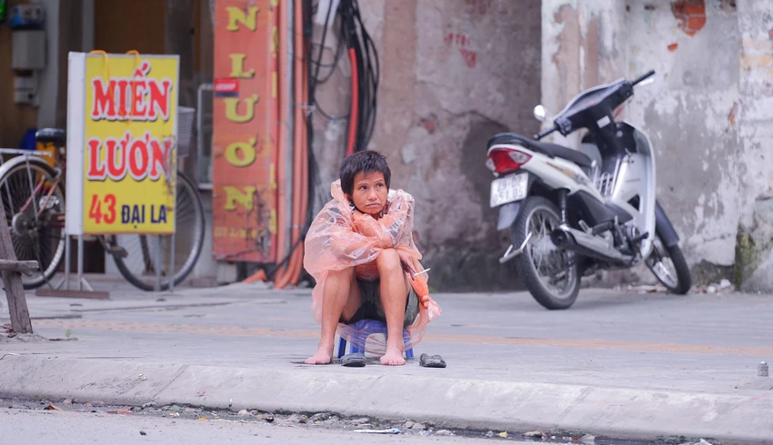 Trên phố Đại La, một người lao động mặc áo mưa ngồi co ro vì lạnh. Trên phố Đại La, một người lao động mặc áo mưa ngồi co ro vì lạnh.