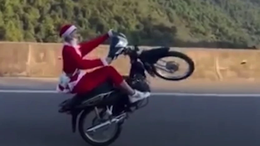 Hình ảnh Tùng mặc quần áo ông già Noel bốc đầu xe trên đường. Ảnh: cắt từ clip Hình ảnh Tùng mặc quần áo ông già Noel bốc đầu xe trên đường. Ảnh: cắt từ clip