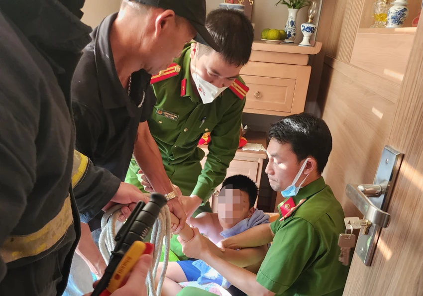 Thời điểm bé trai được lực lượng chức năng giải cứu. Ảnh CA