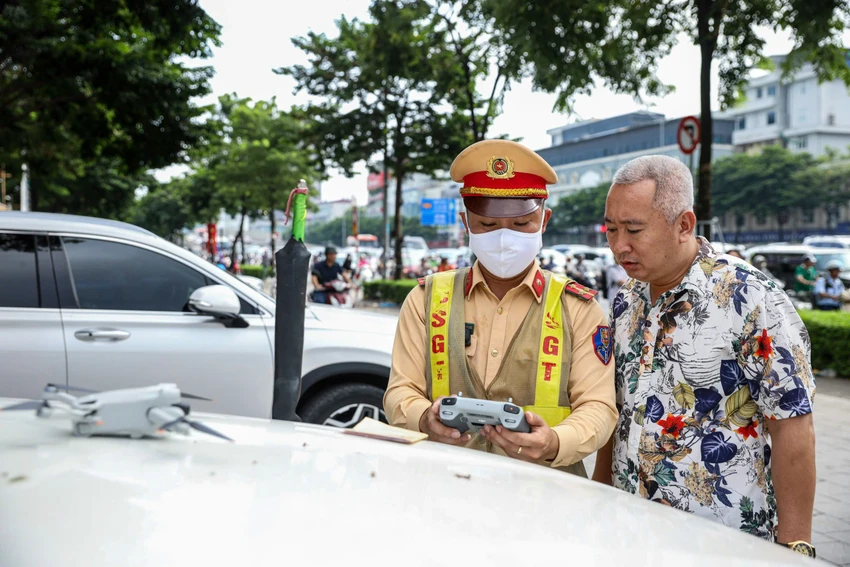 CSGT dừng phương tiện, cho tài xế xem hình ảnh vi phạm.