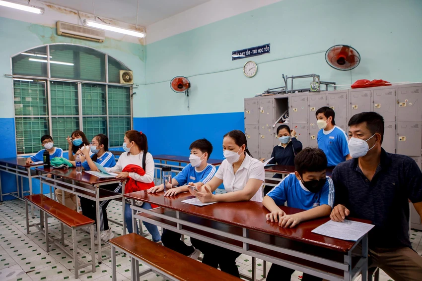 Phụ huynh và học sinh trong phòng chờ thăm khám sức khỏe trước khi tiêm.
