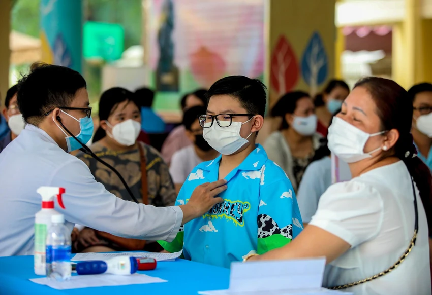 Y bác sĩ thăm khám sức khỏe trước khi tiêm.