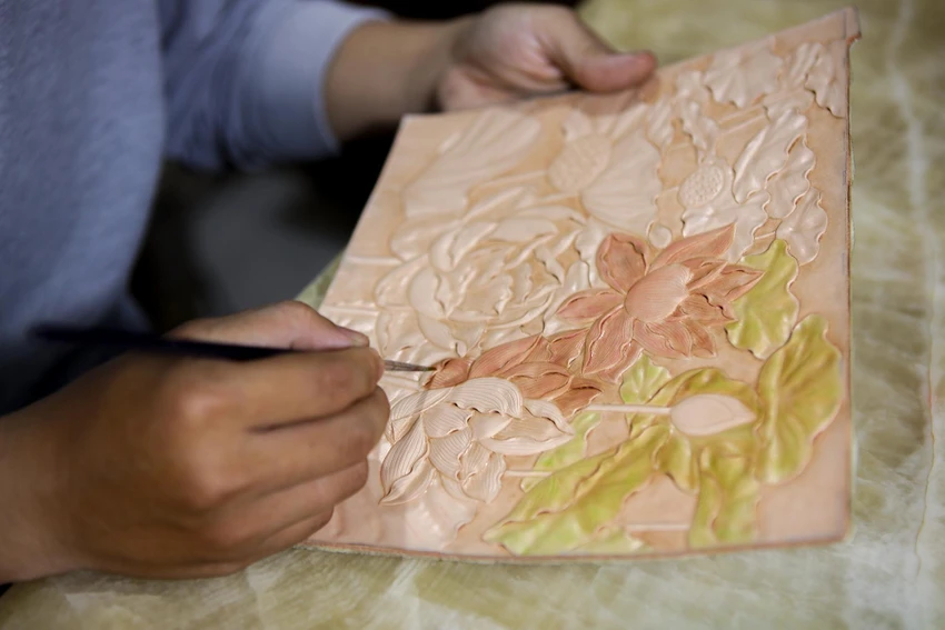 Sau khi điêu khắc, anh Tuấn sẽ lên màu cho sản phẩm. Anh Tuấn dùng màu batik chuyên nhuộm da. Để có được chất màu đậm đà, anh Tuấn cần đợi sản phẩm khô sau đó tô chồng thêm lớp màu. Sau khi điêu khắc, anh Tuấn sẽ lên màu cho sản phẩm. Anh Tuấn dùng màu batik chuyên nhuộm da. Để có được chất màu đậm đà, anh Tuấn cần đợi sản phẩm khô sau đó tô chồng thêm lớp màu.