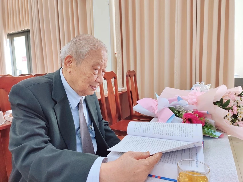 Ông Hai Phước ngồi lại trầm ngâm bên những trang sách sau khi kết thúc buổi lễ. Ảnh: NGUYỄN TRÀ