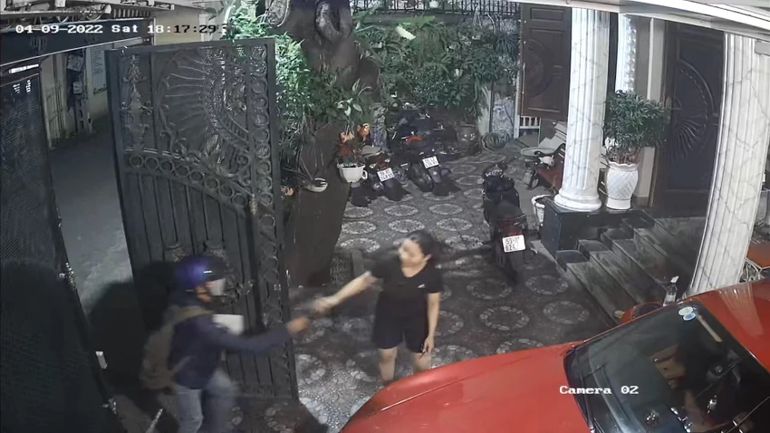 Thái vờ cầm hộp quà vào trong nhà để dàn cảnh cướp tài sản. Ảnh chụp từ clip Thái vờ cầm hộp quà vào trong nhà để dàn cảnh cướp tài sản. Ảnh chụp từ clip