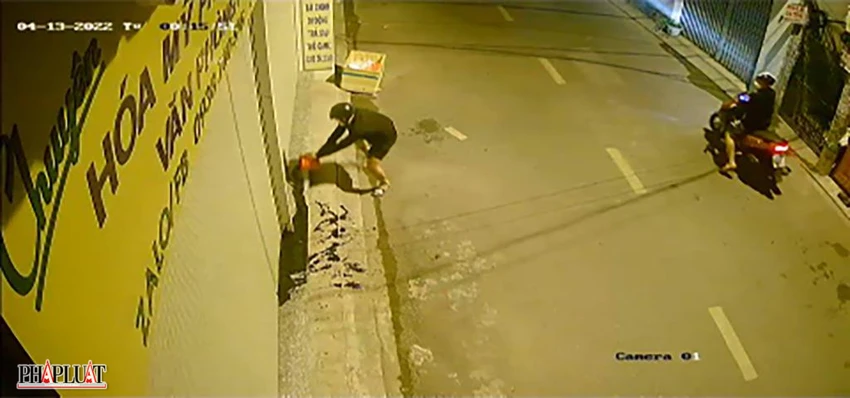 Thanh niên tới tạt nhớt trước cửa hàng buôn bán của người dân trên địa bàn phường Sơn Kỳ, quận Tân Phú. Ảnh chụp từ clip