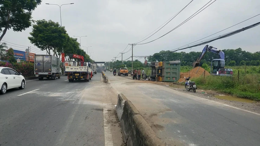 Chiếc xe ben chở cát tông văng dải phân cách, lao sang làn xe máy rồi lật vào lề đường. Ảnh: HT Chiếc xe ben chở cát tông văng dải phân cách, lao sang làn xe máy rồi lật vào lề đường. Ảnh: HT