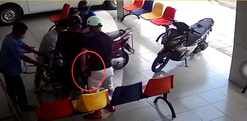 Người này nhét chiếc ví của ông T vào túi quần. Ảnh chụp từ clip Người này nhét chiếc ví của ông T vào túi quần. Ảnh chụp từ clip