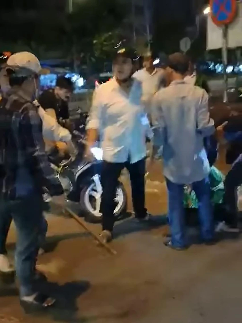 Trong hai người này có một người cầm theo cây gỗ. Ảnh chụp từ clip Trong hai người này có một người cầm theo cây gỗ. Ảnh chụp từ clip