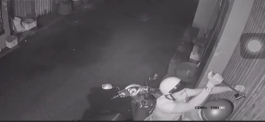 Một người dùng dụng cụ cạy khóa cửa. Ảnh chụp từ clip Một người dùng dụng cụ cạy khóa cửa. Ảnh chụp từ clip
