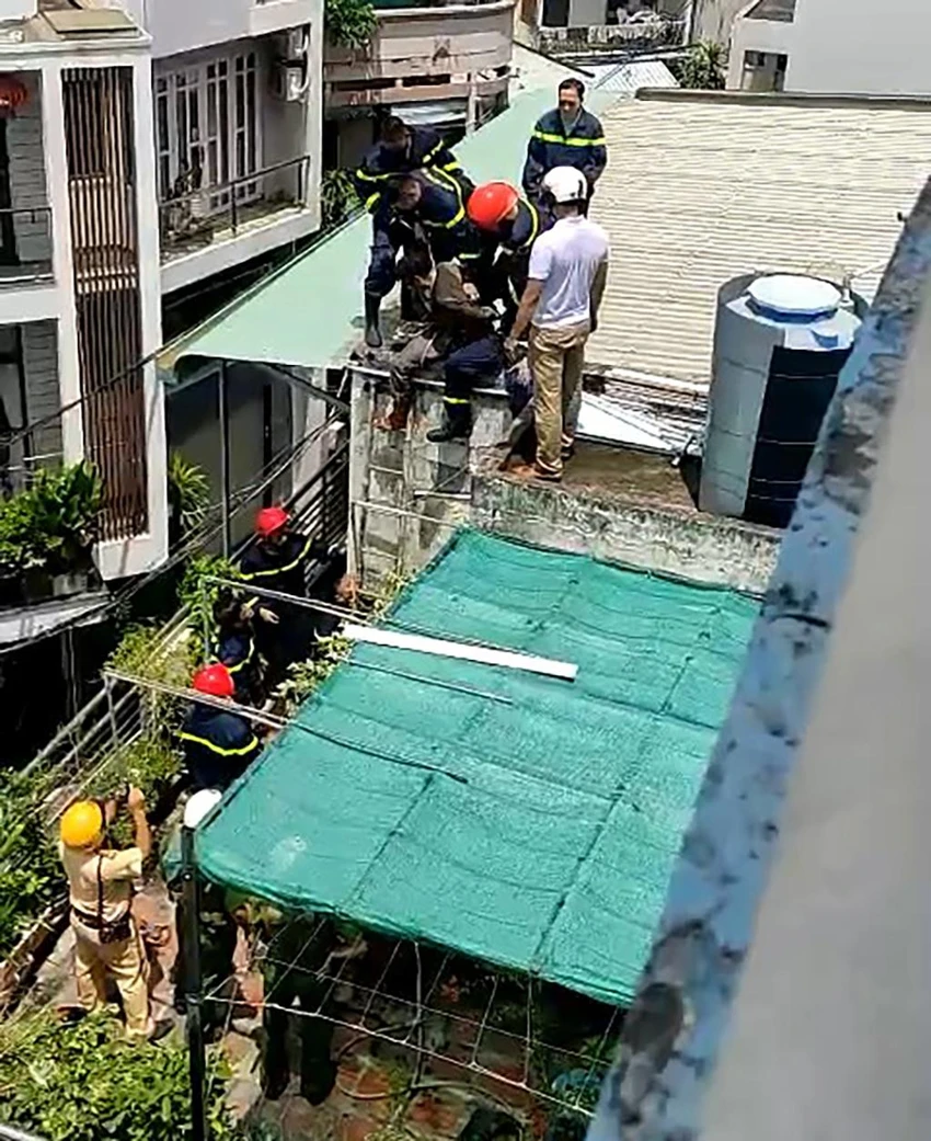 Người đàn ông sau đó leo qua căn nhà gần đó và bị cảnh sát khống chế. Ảnh: CA Người đàn ông sau đó leo qua căn nhà gần đó và bị cảnh sát khống chế. Ảnh: CA